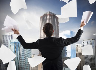 businessman exults and throws work documents