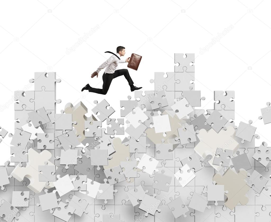 Businessman over a mountain by puzzle