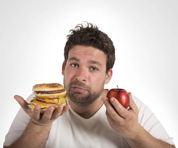 Homem indeciso entre dieta e junk food — Fotografia de Stock