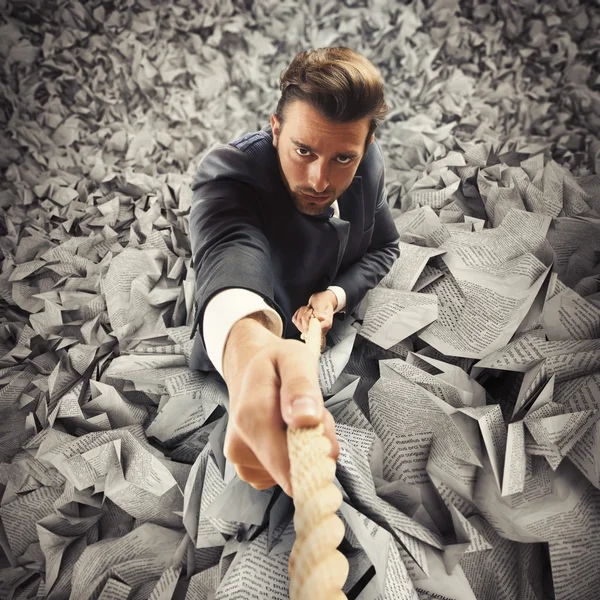 Businessman clinging to rope — Stock Photo, Image