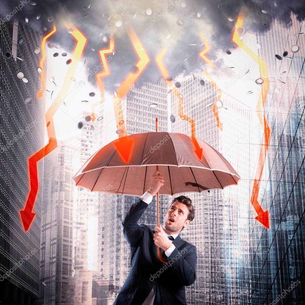 Businessman sheltered with umbrella