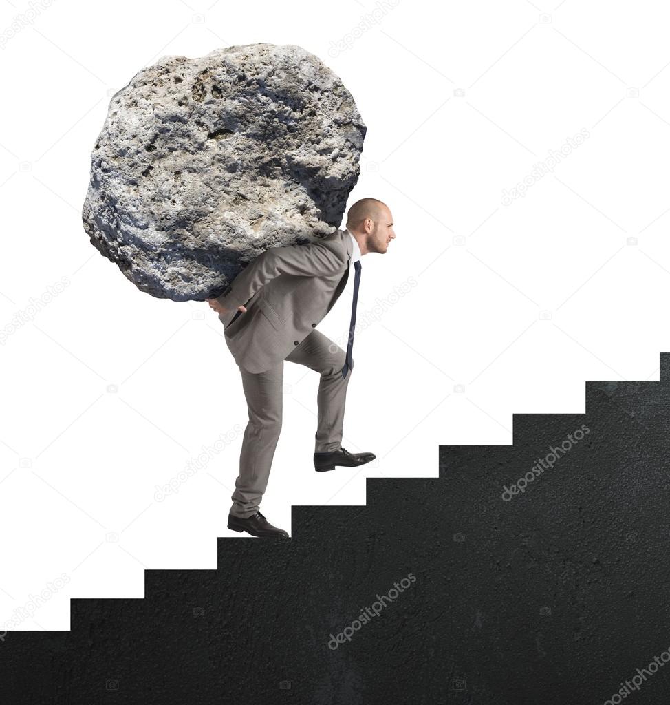 businessman carrying big stone on stairs