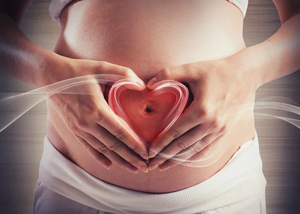 Mulher grávida fazendo um coração — Fotografia de Stock