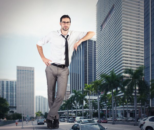 businessman leaning against a skyscraper