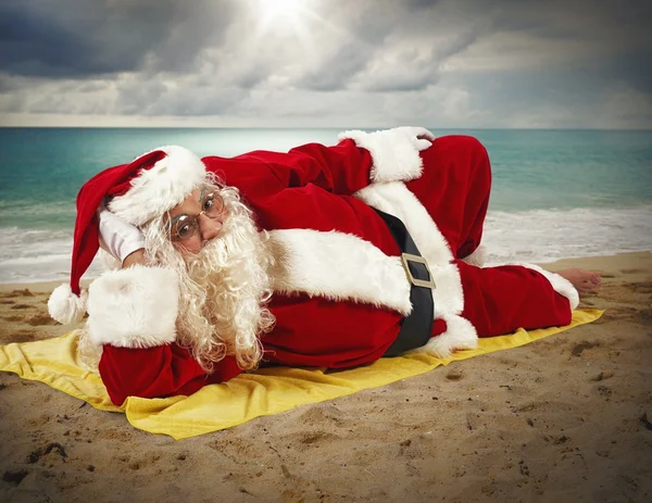 Weihnachtsmann entspannt am Strand — Stockfoto