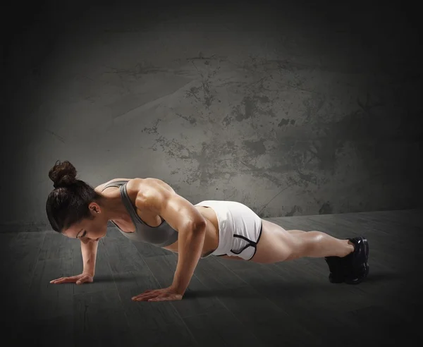 Muskulös kvinna gör push up — Stockfoto