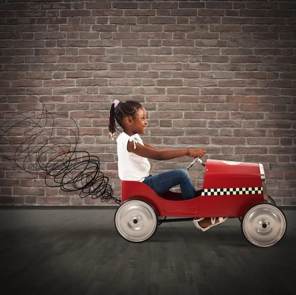 Девушка за рулем игрушечной машины — стоковое фото