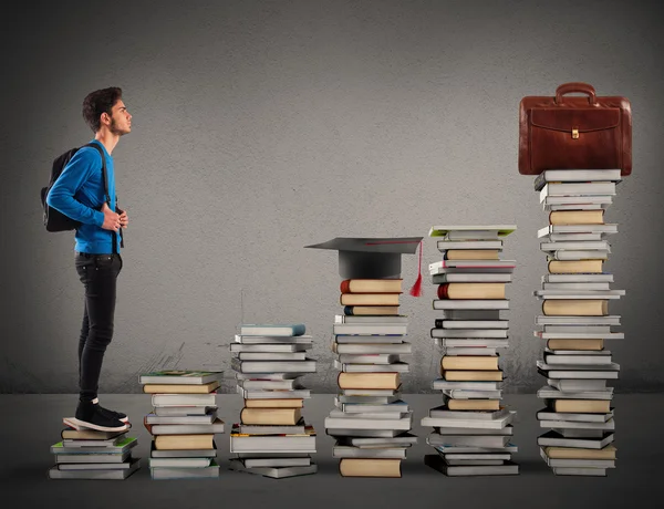 Jongen beklimmen van de trap gemaakt van boeken — Stockfoto