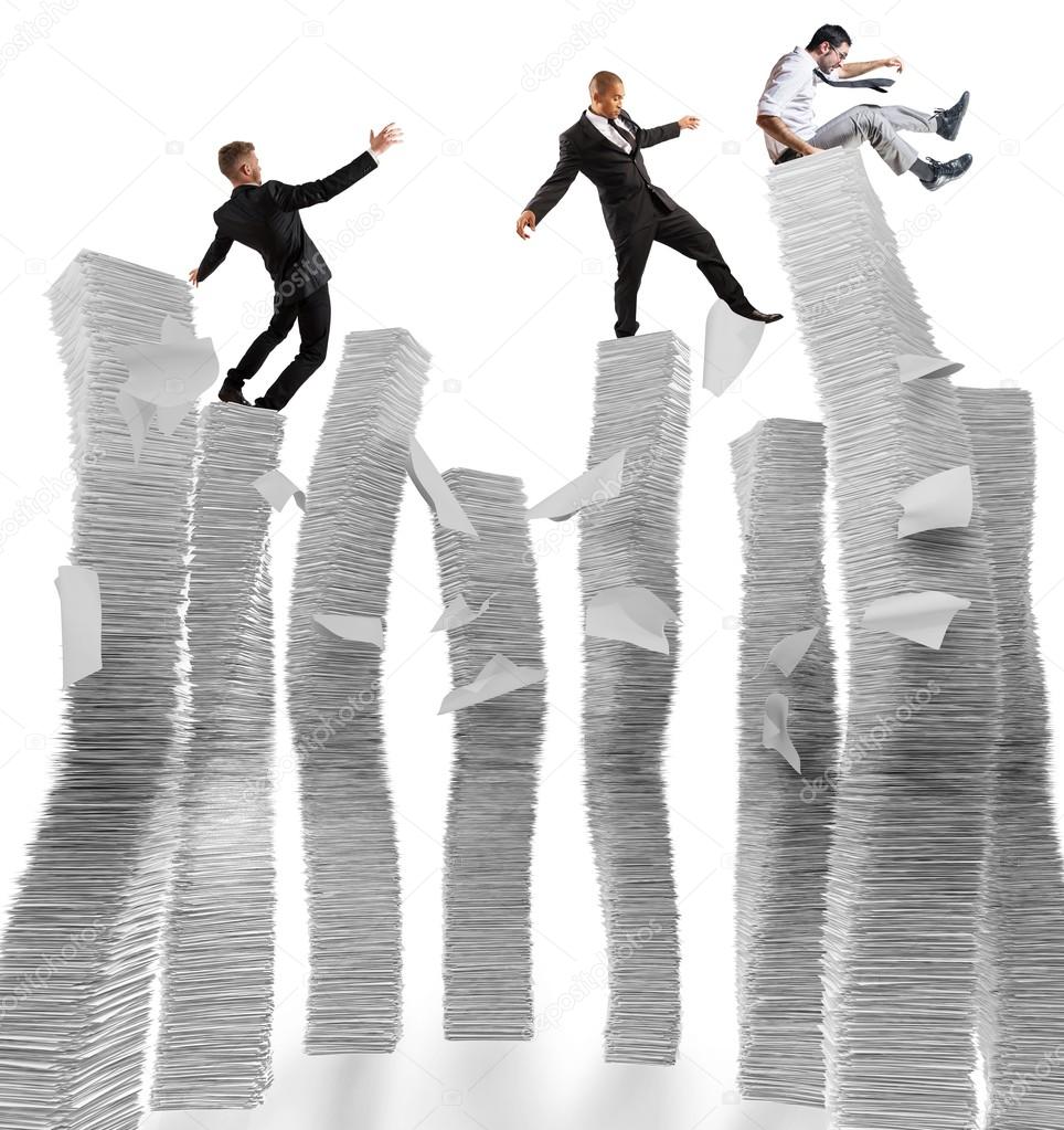 Businessmen on unstable piles of paper