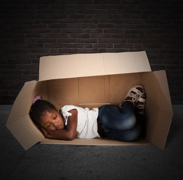 Menina dorme em um papelão — Fotografia de Stock