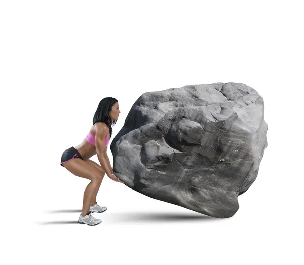 Gespierde vrouw liften een groot rotsblok — Stockfoto