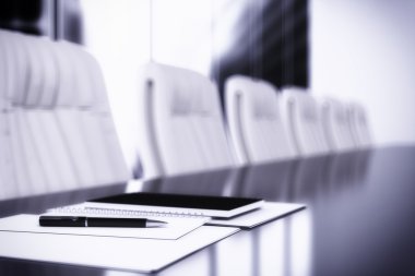Toplantı salonunun içinde tablo üstünde defter