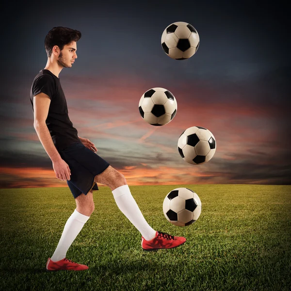 Jogador de futebol driblando com bolas de futebol — Fotografia de Stock