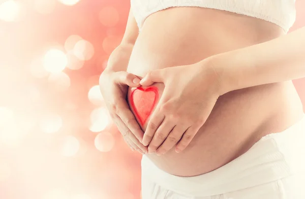 Gravid kvinna att göra ett hjärta med händerna — Stockfoto