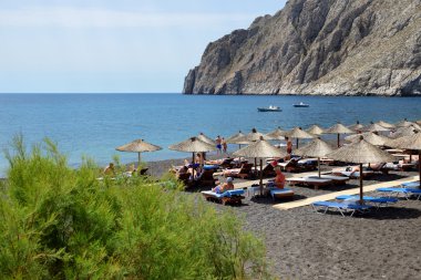 Santorini, Yunanistan - 19 Mayıs: turist üzerinde 19 Mayıs 2014 Santorini, Yunanistan bir plajda tatillerini zevk. Kadar 16 milyon turist Yunanistan 2014 yılında ziyaret etmesi bekleniyor.