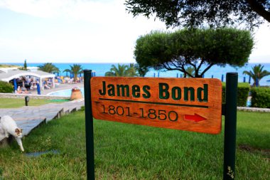 CORFU, GREEES - MAY 16: The tourists are on vacation in luxury hotel where all villas have names related to James Bond movies on May 16, 2016 in Corfu, Greece. Up to 16 mln tourists is expected to visit Greece in year 2016. clipart