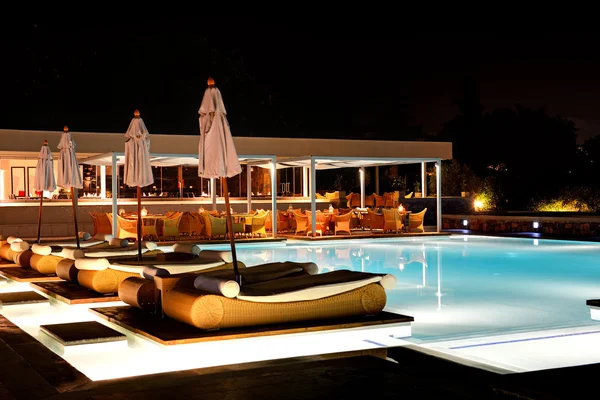 Piscina y bar en la iluminación nocturna en el hotel de lujo , — Foto de Stock