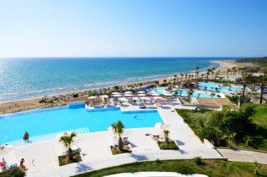 PATRONIKOLEIKA, GREECE - JUNE 10: The beach of luxury hotel and  clipart