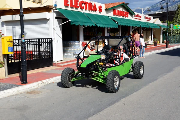 CRETE, GRECIA - 15 DE MAYO: El hombre en un coche de buggy está en una calle, o — Foto de Stock