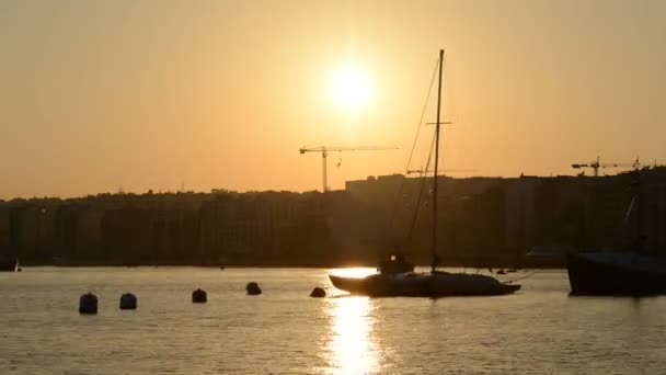Timelaps zachód słońca i widoku na Sliema i żagiel jachtu z flag ukraińskich, Sliema, Malta — Wideo stockowe