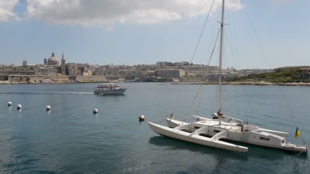 Вид на Валлетту и парусную яхту с украинским флагом и круизную яхту с туристами, Слима, Мальта — стоковое видео