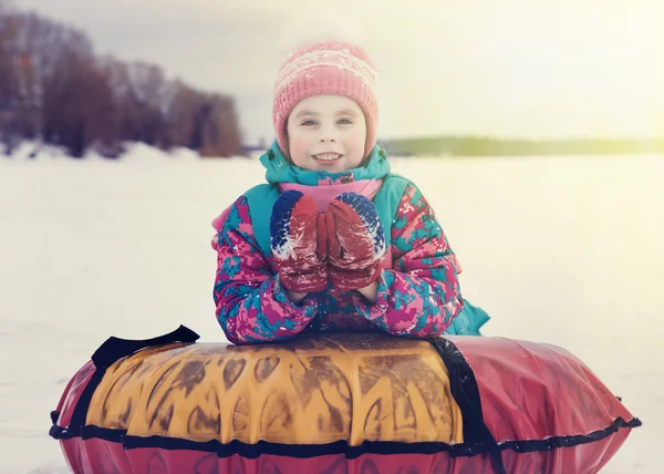 Lovaglás a hóban cső téli nap aranyos gyerek. — Stock Fotó