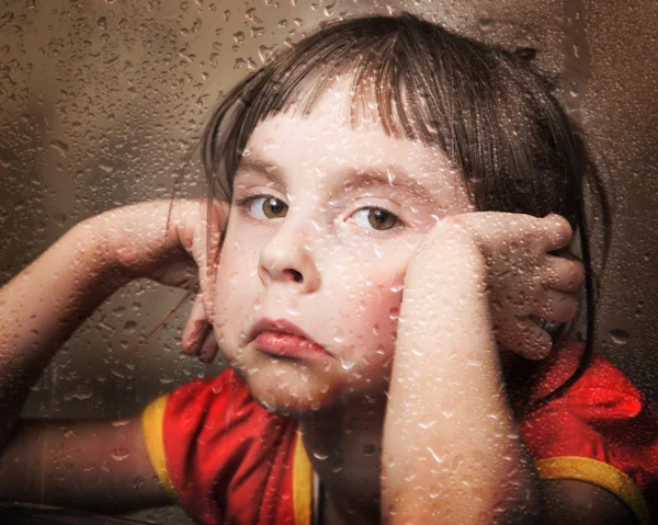 Niño triste en la ventana lluviosa . —  Fotos de Stock