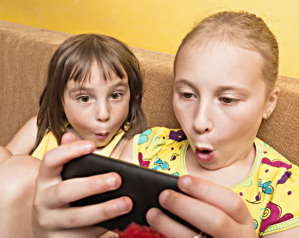 Deux enfants jouent sur votre téléphone mobile . — Photo