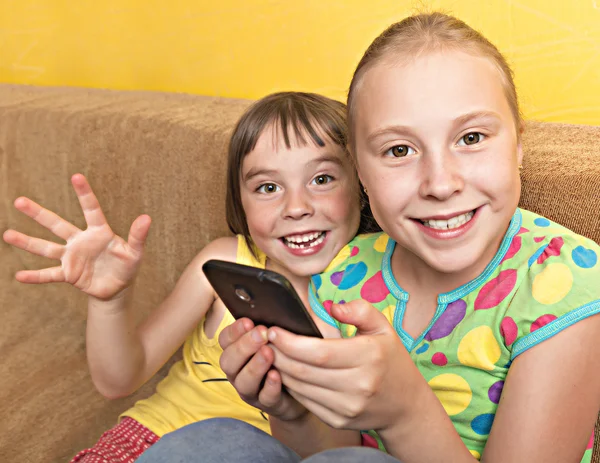 Dos niños juegan en su teléfono móvil . —  Fotos de Stock