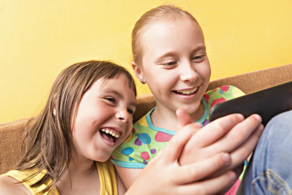 Duas crianças brincam no seu celular . — Fotografia de Stock
