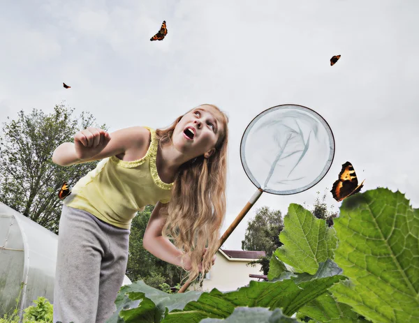 Girl with a net trying to catch butterflies. — Stock Photo, Image