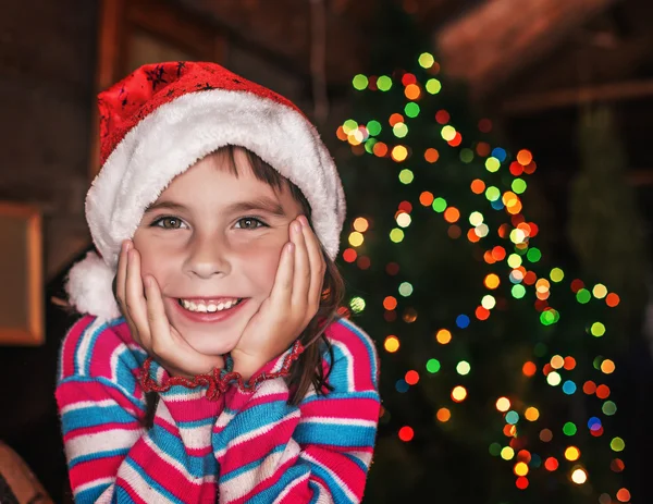 クリスマスライトの背景にいる小さな女の子. — ストック写真