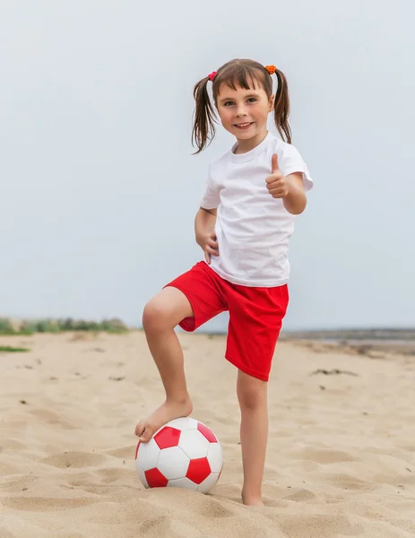 Criança jogando futebol de praia . — Fotografia de Stock