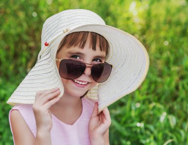 Çocuk gülümseyen güneş gözlüğü ve şapka.
