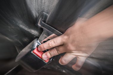 Emniyet kemeri çekti elini.