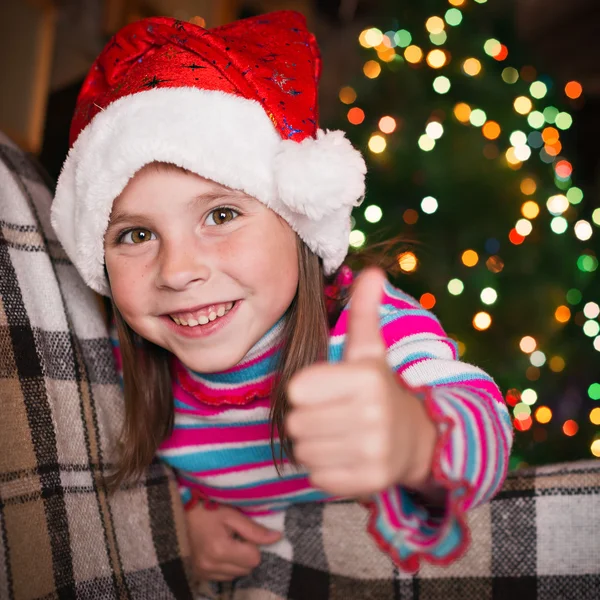 Kleines Mädchen auf dem Hintergrund der Weihnachtsbeleuchtung. — Stockfoto