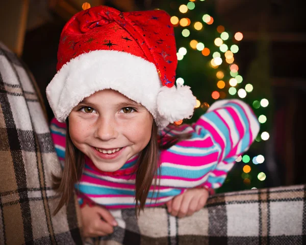 クリスマスライトの背景にいる小さな女の子. — ストック写真