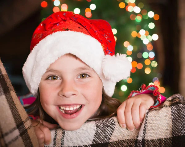 Klein meisje op de achtergrond van kerstverlichting. — Stockfoto