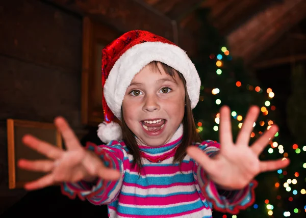 Kleines Mädchen auf dem Hintergrund der Weihnachtsbeleuchtung. — Stockfoto