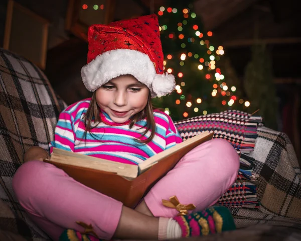 Child reads a book at Christmas. — Stock Photo, Image