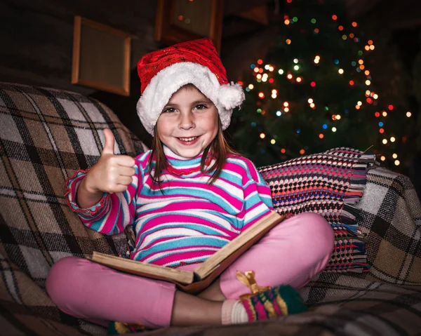 Child reads a book at Christmas. — Stock Photo, Image