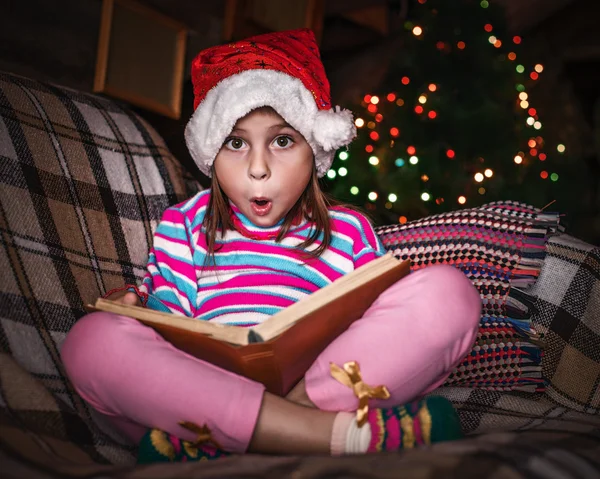 Criança lê um livro no Natal . — Fotografia de Stock