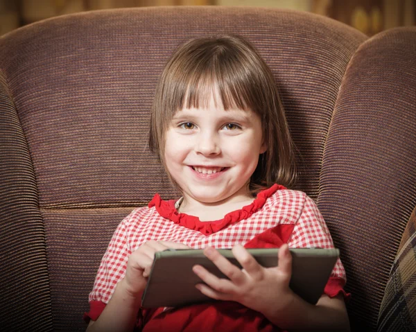 Petite fille jouant avec une tablette numérique moderne . — Photo