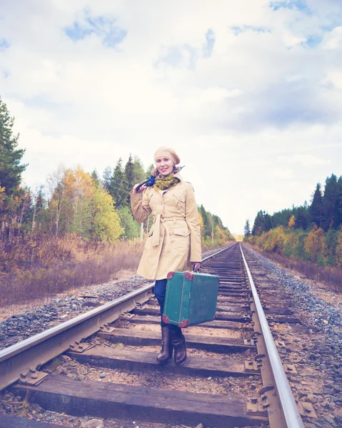 Elegante vrouw met een koffer reizen per spoor. — Stockfoto