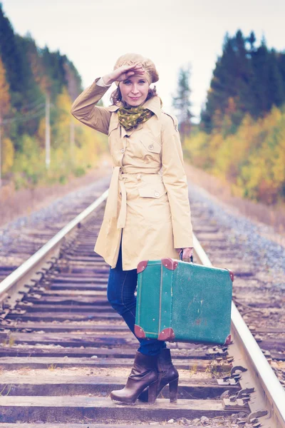 Elegant woman with a suitcase traveling by rail. Stock Photo