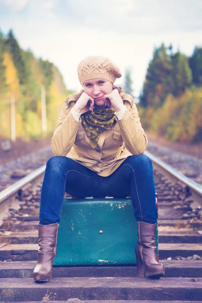 Elegant kvinna med en resväska som reser med tåg. — Stockfoto
