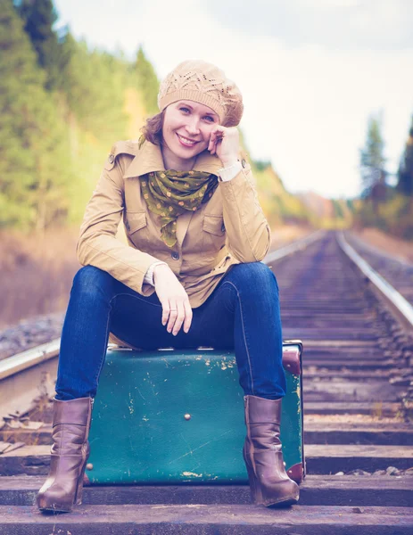 Elegante vrouw met een koffer reizen per spoor. — Stockfoto