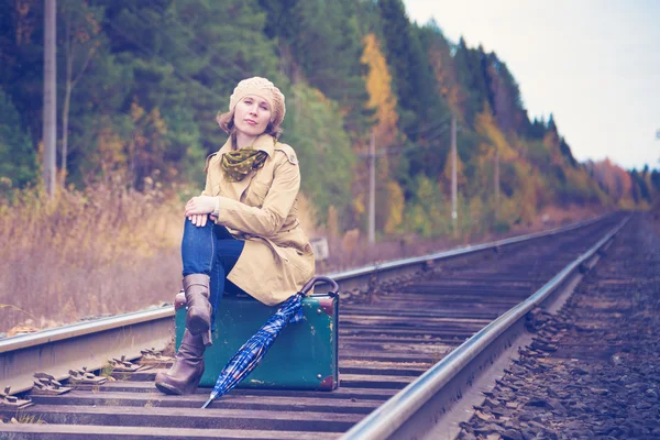 Elegante vrouw met een koffer reizen per spoor. — Stockfoto