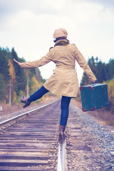 Elegante vrouw met een koffer reizen per spoor. — Stockfoto