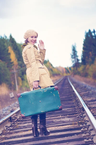 Elegant woman with a suitcase traveling by rail. Stock Picture